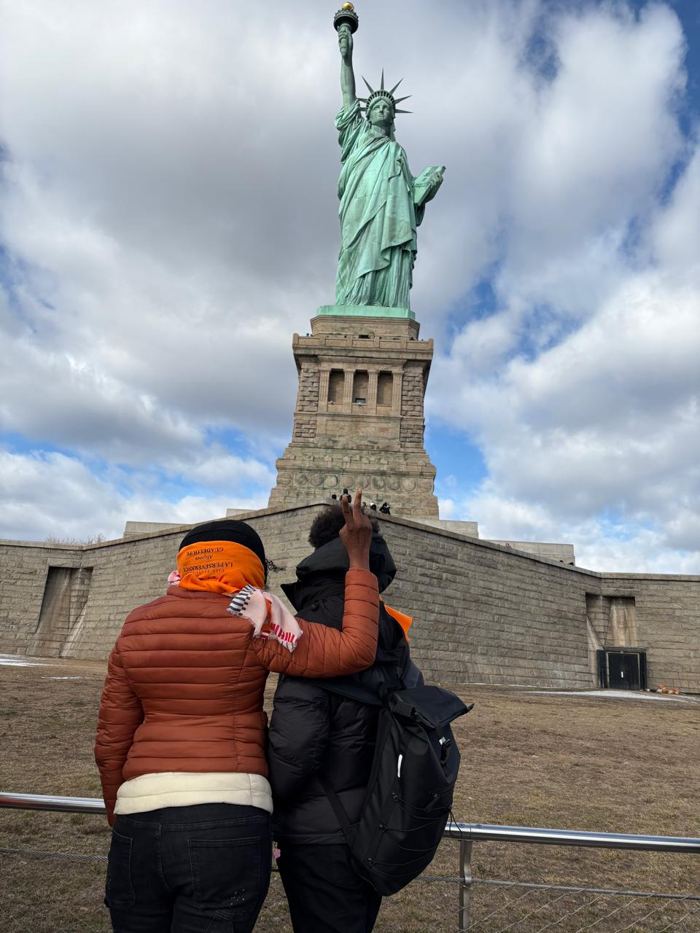 Devant la statue de la Liberté